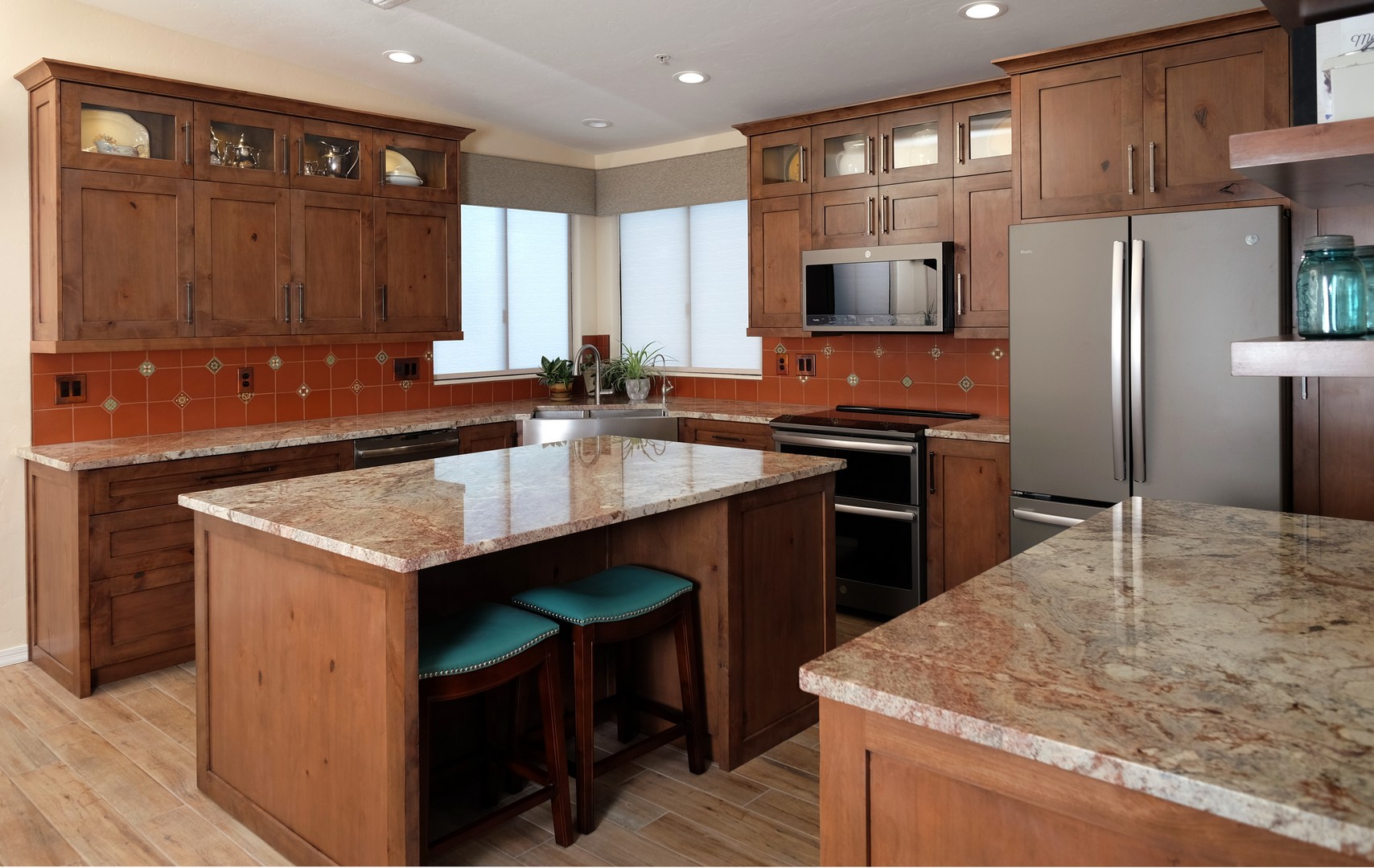 Tucson Southwestern kitchen design and remodel with Spanish Colonial Revival style featuring Mexican deco and terra cotta tiles, knotty custom cabinetry, and teal & turquoise accents.