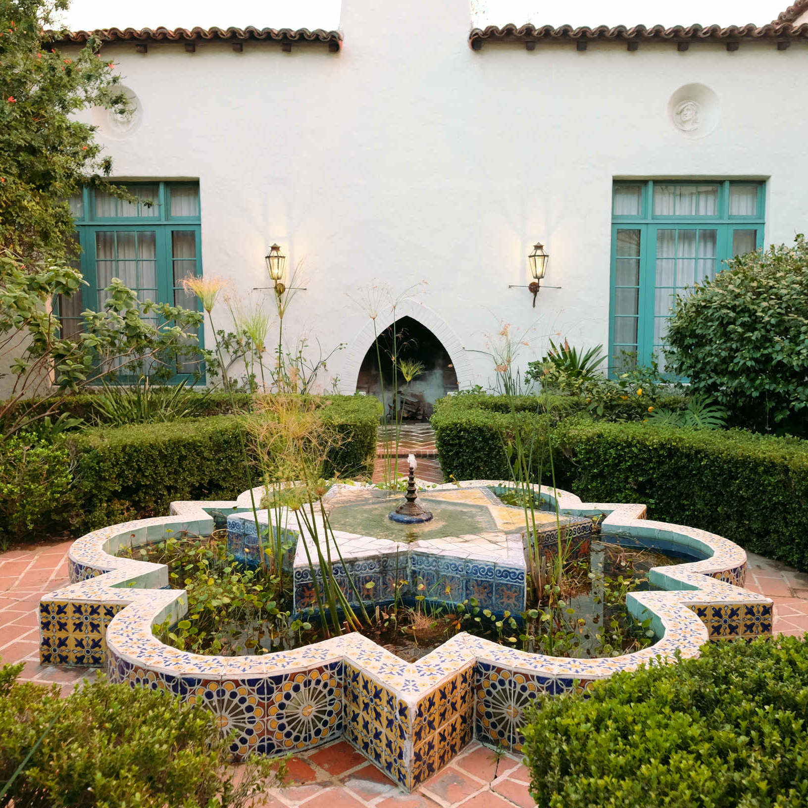 Moroccan tile fountain in Alhambra Apartments courtyard with turquoise windows